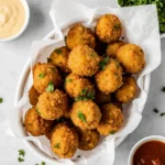 Overhead shot of crispy Tyson air fryer chicken nuggets with sauces on a white parchment-lined plate